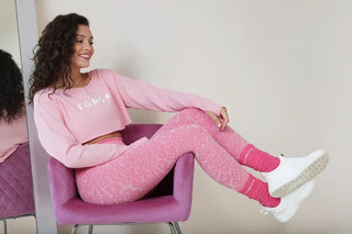 Fata poartă un set sport cu top și colanți push-up de la FGM04 pentru antrenamentele la sală.