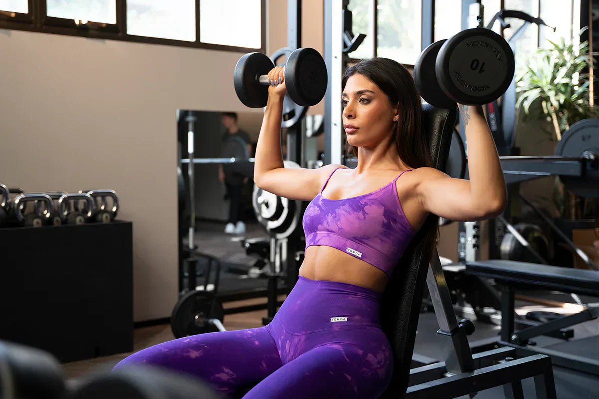 ragazza esegue esercizi con pesetti indossando set palestra maltinto 