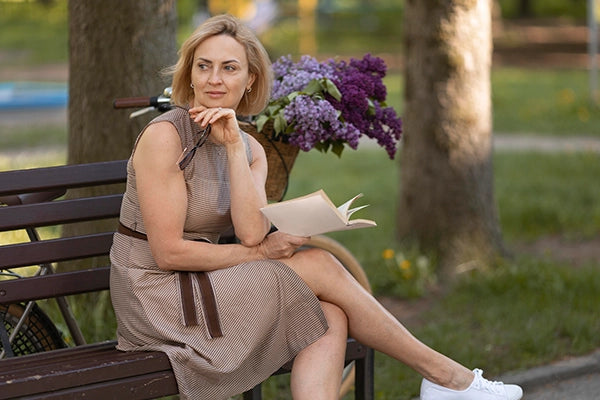 donna che legge un libro al parco