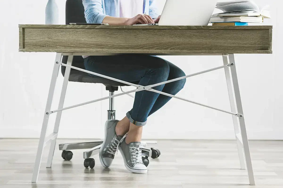 donna che lavora al tavolo del piccolo ufficio