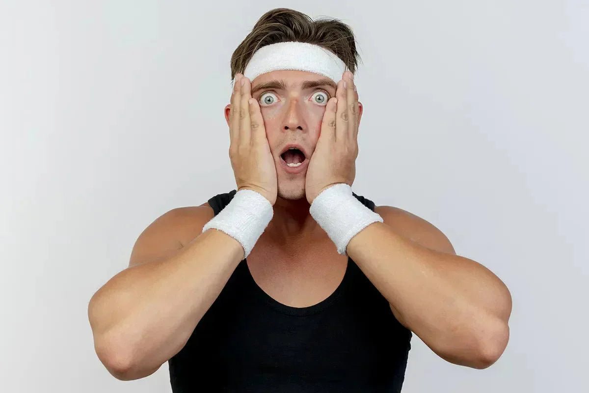 giovane uomo sportivo con le mani in faccia e lo sguardo sorpreso